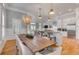 Dining room with a long table connects to a modern kitchen and a cozy living area at 108 Carolina Blvd, Isle of Palms, SC 29451