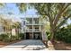 Two-story home has a front porch on each level with a paved driveway and garage parking at 108 Carolina Blvd, Isle of Palms, SC 29451