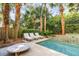 Private backyard pool with lush landscaping, lounge chairs, and a serene water feature at 108 Carolina Blvd, Isle of Palms, SC 29451