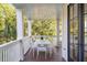 Relaxing outdoor porch features a dining table and chairs, perfect for enjoying the natural surroundings at 108 Carolina Blvd, Isle of Palms, SC 29451