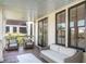 Inviting outdoor porch with cozy seating and stylish black-framed glass doors at 108 Carolina Blvd, Isle of Palms, SC 29451