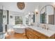 Bright bathroom featuring a soaking tub, dual vanities, and a large window with a garden view at 1081 Groves Manor Ct, Mount Pleasant, SC 29464