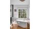 Bright bathroom featuring a soaking tub, dual vanities, and a large window with a garden view at 1081 Groves Manor Ct, Mount Pleasant, SC 29464