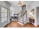 Bright and welcoming foyer featuring hardwood floors, elegant staircase, stylish lighting, and an adjacent dining area at 1081 Groves Manor Ct, Mount Pleasant, SC 29464