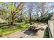 Backyard patio with a wooden table is surrounded by lush landscaping and mature trees. The home is in the background at 1081 Groves Manor Ct, Mount Pleasant, SC 29464