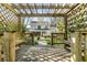 View from inside the wooden pergola looking out onto the expansive backyard and the two-story home at 1081 Groves Manor Ct, Mount Pleasant, SC 29464