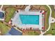 Aerial view of sparkling community pool with lounge seating and red umbrellas, a luxury outdoor amenity at 109 Crosscut Ln, Summerville, SC 29486