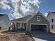 Charming single-story home featuring a two-car garage, covered porch, and green siding at 109 Crosscut Ln, Summerville, SC 29486