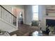 Cozy living room with a fireplace, large windows, staircase, and view into entryway at 109 Crosscut Ln, Summerville, SC 29486