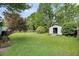 Expansive backyard featuring a well-maintained lawn, storage shed, and mature trees at 1135 Shoreham Rd, Charleston, SC 29412