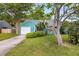 Charming blue-green house featuring a well-maintained front yard, a garage and lovely landscaping at 1135 Shoreham Rd, Charleston, SC 29412