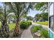Charming street view with lush landscaping, including palm trees and flowering plants at 1135 Shoreham Rd, Charleston, SC 29412