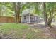 View of backyard with patio, screened porch, and mature trees providing ample shade at 115 Ridge Rd, Summerville, SC 29485