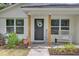 Inviting front porch with rocking chair, wreath on door, and charming 'welcome' sign at 115 Ridge Rd, Summerville, SC 29485
