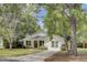 View of a cute home with a lawn and front door; a tree stands to the left at 115 Ridge Rd, Summerville, SC 29485