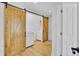 Bright laundry room features washer and dryer behind sliding barn door; white walls and light wood floors at 115 Ridge Rd, Summerville, SC 29485