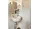 Elegant bathroom with pedestal sink, mirror, and a built-in cabinet at 116 Magnolia Ave, Charleston, SC 29403