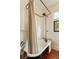 Traditional bathroom featuring a clawfoot bathtub with black fixtures and wood floors at 116 Magnolia Ave, Charleston, SC 29403