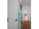 Bright hallway featuring wood floors and closet with blue checkered curtain, leading to a cozy living area at 1300 Ocean Blvd # 308, Isle of Palms, SC 29451