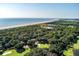 Stunning aerial view of coastal real estate, showcasing lush greenery, ocean, and golf course at 1365 Dunlin Court, Share D, Kiawah Island, SC 29455