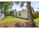 View of the home's backyard, enclosed by a white fence, with a mix of mature trees and grass at 1366 W Point Dr, Mount Pleasant, SC 29466