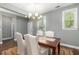 Elegant dining room featuring a chandelier, a large table with white upholstered chairs, and a view to the outside at 1417 Roustabout Way, Charleston, SC 29414