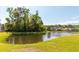 Scenic pond view with mature trees and manicured grass in a residential community at 1417 Roustabout Way, Charleston, SC 29414