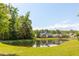 Scenic view of a tranquil pond surrounded by lush greenery and well-maintained homes in a residential community at 1417 Roustabout Way, Charleston, SC 29414
