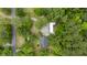 Aerial view of a property nestled among trees, featuring a house, outbuilding, and surrounding landscape at 158 Whippoorwill Dr, Summerville, SC 29483