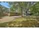 Expansive backyard showcasing the house exterior, an outbuilding, and a mix of grassy areas and trees at 158 Whippoorwill Dr, Summerville, SC 29483