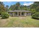 Inviting one-story home featuring a red front door with white columns, complemented by a verdant front yard at 158 Whippoorwill Dr, Summerville, SC 29483