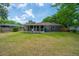 Large backyard featuring a well-manicured lawn, brick home, and a charming screened-in porch for relaxing outdoors at 1707 Sharon Ave, Charleston, SC 29407