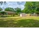 Well-maintained backyard featuring a lush lawn, brick home, and a storage shed, ideal for outdoor activities and storage at 1707 Sharon Ave, Charleston, SC 29407
