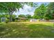 Spacious backyard featuring lush lawn, mature trees, storage shed, and a charming brick home, perfect for outdoor enjoyment at 1707 Sharon Ave, Charleston, SC 29407