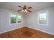 A light-filled bedroom with original hardwood floors and two large windows at 1707 Sharon Ave, Charleston, SC 29407