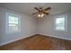 A sun-filled bedroom with original hardwood floors and two large windows at 1707 Sharon Ave, Charleston, SC 29407