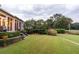 Expansive backyard featuring lush landscaping, mature trees, and a view of the golf course beyond the property line at 187 Ithecaw Creek St, Daniel Island, SC 29492