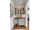Wet bar area features a beverage refrigerator, glass door cabinets, dark countertop and sink at 187 Ithecaw Creek St, Daniel Island, SC 29492