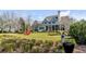 Beautiful blue home with lush lawn, mature landscaping, and inviting curb appeal on a sunny day at 187 Ithecaw Creek St, Daniel Island, SC 29492