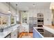 Bright kitchen features a farmhouse sink, stainless steel appliances, and custom cabinets with hardwood floors at 187 Ithecaw Creek St, Daniel Island, SC 29492