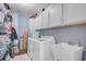 Functional laundry room with modern appliances, storage cabinets, and a utility sink at 209 Cheyenne Rd, Summerville, SC 29483