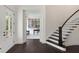 Welcoming foyer with dark wood floors, a curved staircase, and a view into the study at 2372 Darts Cove Way, Mount Pleasant, SC 29466