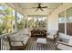 Inviting covered porch features comfortable seating, a wooden dining table and serene wooded views at 2372 Darts Cove Way, Mount Pleasant, SC 29466