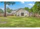 Well-maintained backyard featuring a lush green lawn, privacy fence, and a cozy patio accessible from the house at 2427 Stingray Blvd, North Charleston, SC 29406