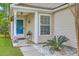 Inviting front porch featuring a blue door, decorative plants, and white stone landscaping at 2427 Stingray Blvd, North Charleston, SC 29406