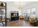 Bright living room with piano, yellow chairs, chandelier, and natural light from multiple windows at 247 Godwit Dr, Summerville, SC 29486