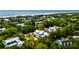 Scenic aerial shot of a coastal community with numerous homes surrounded by dense trees and a pristine beach at 2870 Ion Ave, Sullivans Island, SC 29482