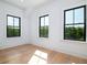 Bright bedroom featuring hardwood floors and black framed windows with a lush view at 2870 Ion Ave, Sullivans Island, SC 29482