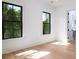 Bright bedroom featuring hardwood floors and black framed windows with a lush view at 2870 Ion Ave, Sullivans Island, SC 29482