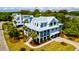 Stunning home with a metal roof, charming porch, palm trees, and a paved driveway amidst a lush landscape at 2870 Ion Ave, Sullivans Island, SC 29482